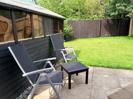 A garden with chairs and a table at 7 Cwrt Y Cadno in Llantwit Major