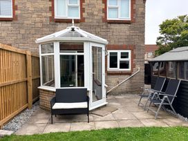 A conservatory with seating adjacent to a garden at 7 Cwrt Y Cadno Llantwit Major