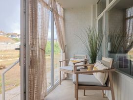 A conservatory with chairs and a potted plant at 4 Kingfisher Court in West Bay