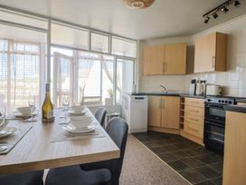 A kitchen with a dining table and dining ware at 4 Kingfisher Court West Bay