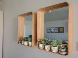 A wall with mirrors and decorative plants at 4 Kingfisher Court in West Bay