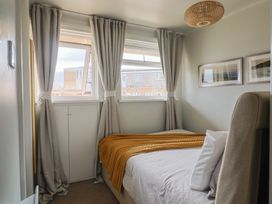 A bedroom with a bed and curtains at 4 Kingfisher Court West Bay