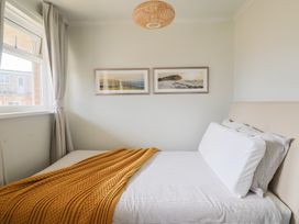 A bedroom with a bed and paintings on the wall at 4 Kingfisher Court in West Bay