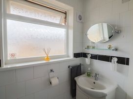 A bathroom with sink and mirror at 4 Kingfisher Court West Bay