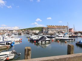 A marina with boats and buildings at 4 Kingfisher Court in West Bay