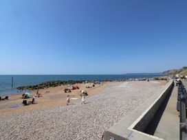 A beach with people and umbrellas at 4 Kingfisher Court in West Bay