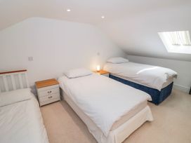 A bedroom with three single beds and a nightstand at Wayside, Moreton-in-Marsh