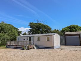 A mobile home with a deck and garage at The Hideaway in Portesham
