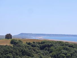A view of a building on hills overlooking the ocean at The Hideaway in Portesham