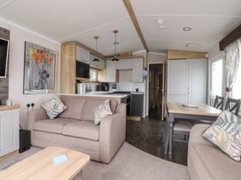 A living room with a sofa and dining area at Marton Mere Westminster Blackpool
