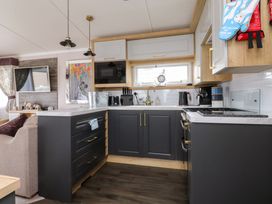 A kitchen with cabinets and cooking appliances at Marton Mere Westminster in Blackpool