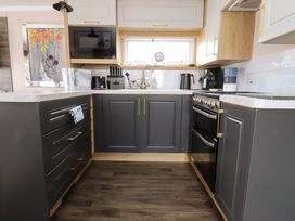 A kitchen with cabinets, sink, stove, and appliances at Marton Mere Westminster in Blackpool