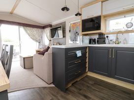 A living room and kitchen space with a sofa and kitchen counter at Marton Mere Westminster Blackpool