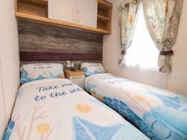 A bedroom with two beds and a nightstand at Marton Mere Westminster in Blackpool