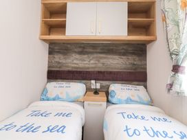 A bedroom with two beds and a shelf at Marton Mere Westminster Blackpool
