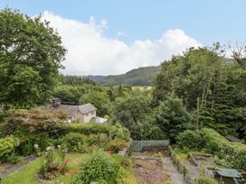 A garden with flowers and trees overlooking mountains at Awelfryn in Betws-y-Coed