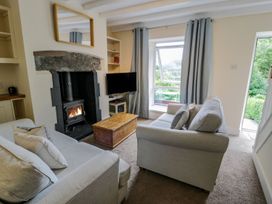 A living room with a fireplace and a television at Awelfryn in Betws-y-Coed