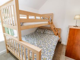 A bunk bed with a double bed in a bedroom at Awelfryn in Betws-y-Coed