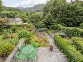 A garden with a table and chairs overlooking greenery at Awelfryn Betws-y-Coed