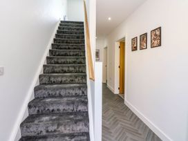 A hallway with staircase and pictures at Sycamore Cottage in Frizington