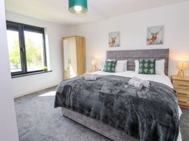 A bedroom with a bed and wardrobe at Sycamore Cottage in Frizington