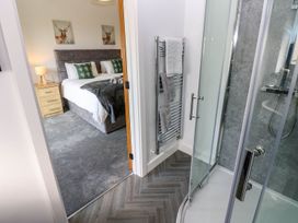 A bathroom with a shower and adjoining bedroom at Sycamore Cottage Frizington