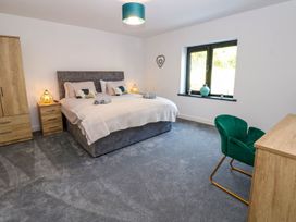 A bedroom with a bed and dresser at Sycamore Cottage in Frizington
