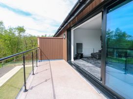 A balcony with a glass door and sofa at Sycamore Cottage in Frizington
