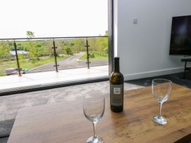 A living room with a wine bottle and glasses at Silver Birch Cottage in Frizington