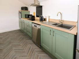 A kitchen with cabinets and appliances at Silver Birch Cottage in Frizington