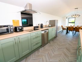 A kitchen with cabinets and appliances at Silver Birch Cottage in Frizington