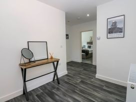 A hallway with a console table and mirror at Silver Birch Cottage in Frizington