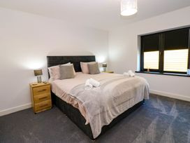 A bedroom with a bed and bedside tables at Silver Birch Cottage in Frizington