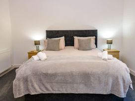 A bedroom with a bed and bedside tables at Silver Birch Cottage in Frizington