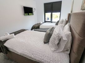 A bedroom with two beds and a television at Silver Birch Cottage in Frizington