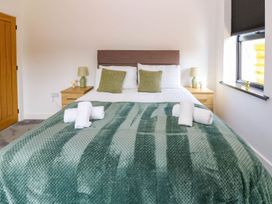 A bedroom with a bed and nightstand at Silver Birch Cottage in Frizington
