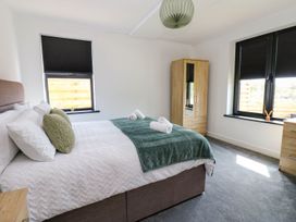 A bedroom with a bed and wardrobe at Silver Birch Cottage in Frizington