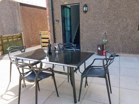 An outdoor dining area with a table and chairs at Silver Birch Cottage Frizington