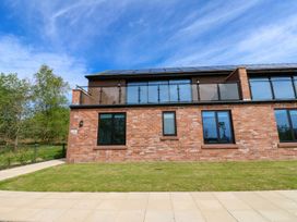 A building with a balcony and windows at Oak Tree Cottage in Frizington