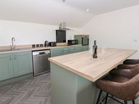 A kitchen with modern appliances and a breakfast bar at Oak Tree Cottage in Frizington