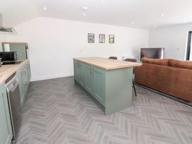 A kitchen with an island and seating at Oak Tree Cottage in Frizington