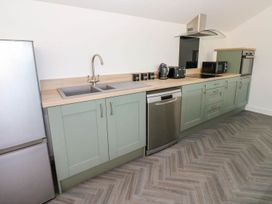 A kitchen with cabinets and appliances at Oak Tree Cottage in Frizington