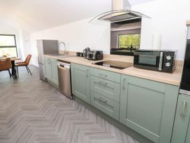 A kitchen with appliances and a dining area at Oak Tree Cottage in Frizington