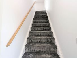 A staircase with a handrail and carpet at Oak Tree Cottage in Frizington