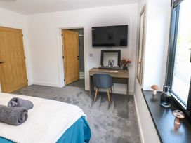 A bedroom with a bed and desk at Oak Tree Cottage in Frizington