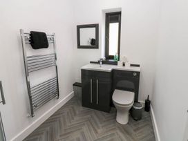 A bathroom with a sink, toilet, and towel rail at Oak Tree Cottage in Frizington