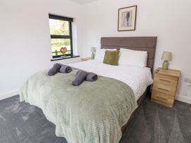 A bedroom with a double bed and bedside table at Oak Tree Cottage in Frizington