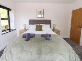 A bedroom with a bed and bedside tables at Oak Tree Cottage in Frizington