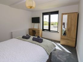 A bedroom with a bed and a desk at Oak Tree Cottage in Frizington