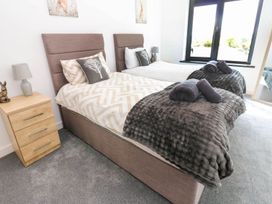 A bedroom with two beds and a lamp at Oak Tree Cottage in Frizington